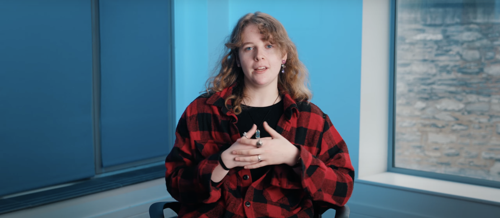 Video thumbnail of Charlie standing next to a red brick wall.