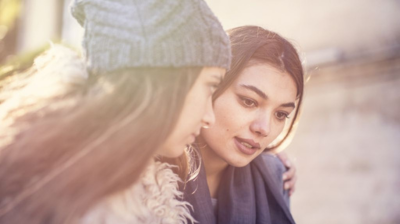 Image of two people talking to each other outside in the winter