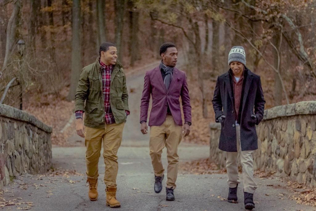 Illustrative image of a group of friends smiling and waving the rainbow flag.