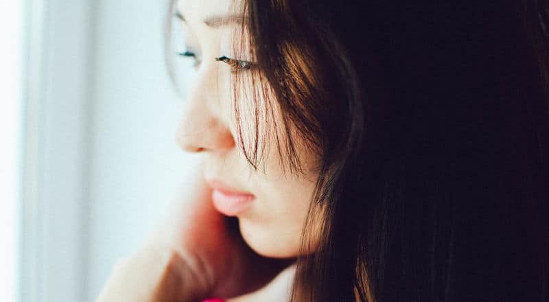 Illustrative image showing the side of a person's face looking into the distance with a sad expression.