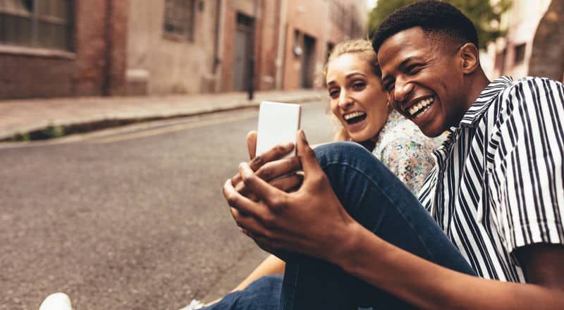 Illustrative image of a smiling couple in a car driving through the countryside.