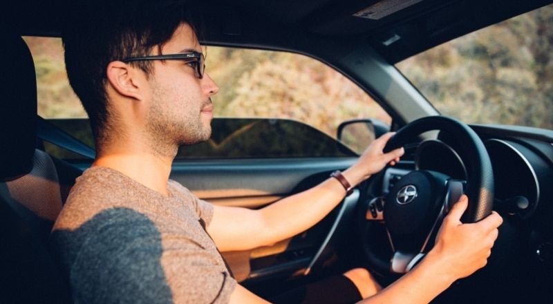 Illustrative image of a sad person sitting and looking out a window.