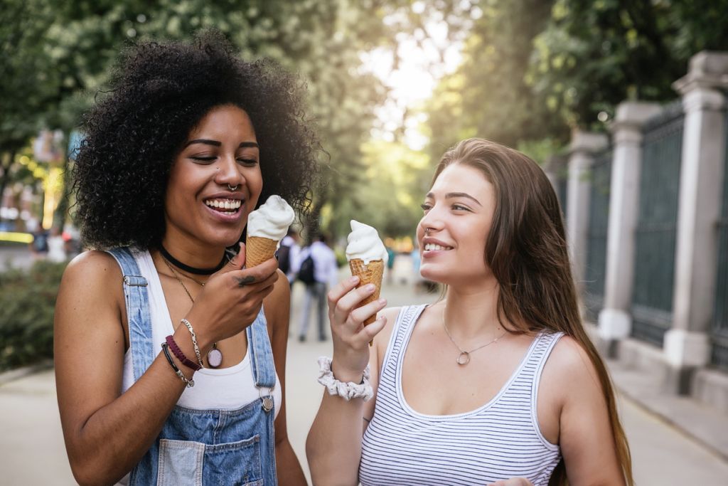 Illustrative image of two people eating ice cream together in an urban area.