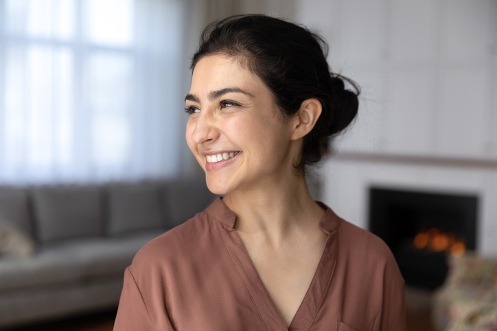 Illustrative image of a person smiling in a cosy indoor setting.