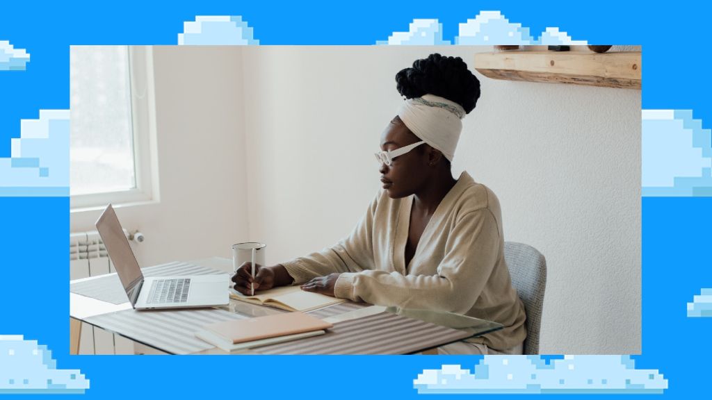 Illustrative image of a person writing in a journal at a table with an open laptop, a cup and a couple of stacked notepads. 
