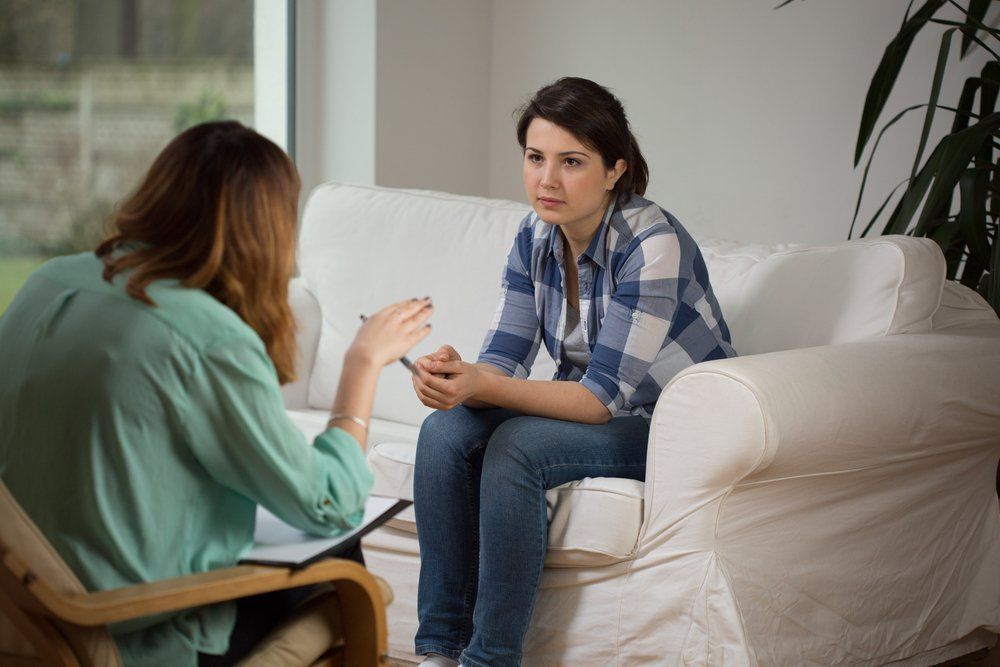 Illustrative image of two seated people conversing in an office.