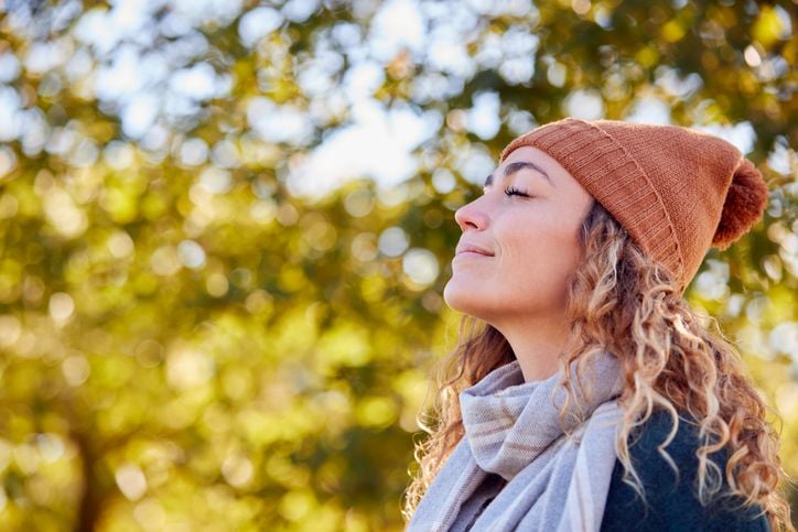 Illustrative photo of a person with their eyes closed, smiling