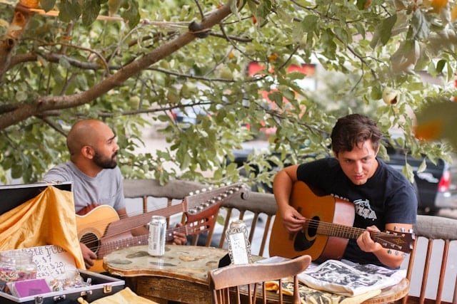 Illustrative image of two people sitting together while playing guitars.