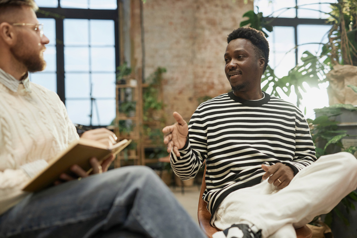 Illustrative image of a person talking to another person on chairs in a circle.