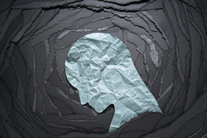 Silhouette of a person's sad head against a black background.