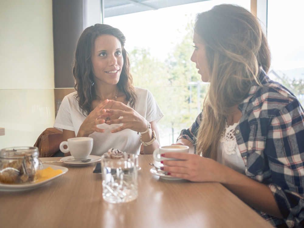 Illustrative image of smiling a person walking with a group of their peers with a bag slung over their shoulder.