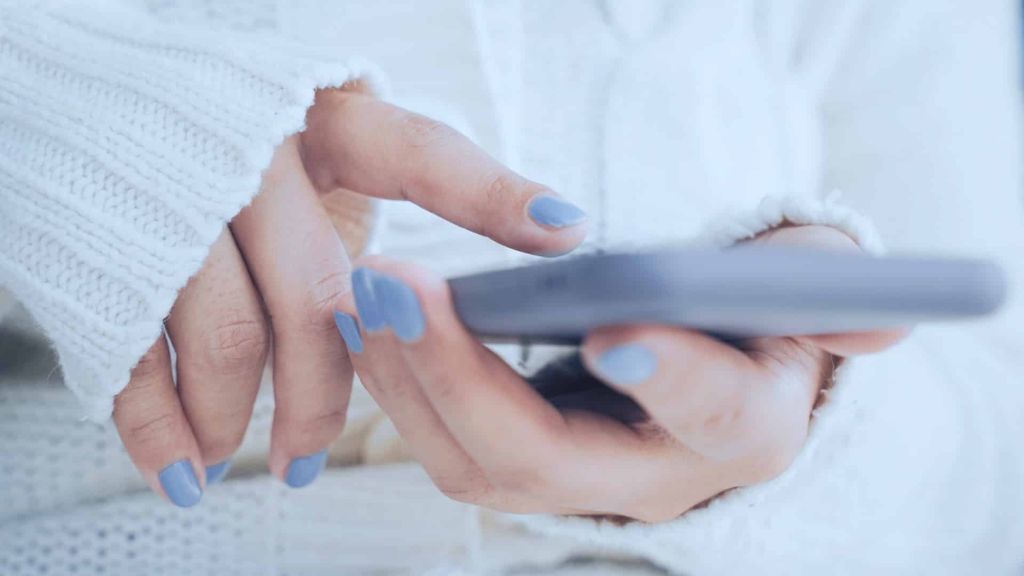 Illustrative image of a person's fingers scrolling on their phone.