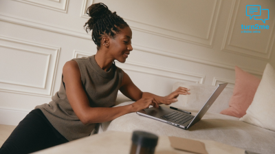 Woman types on her laptop talking to someone on the computer.