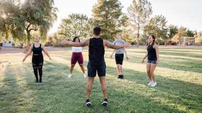 Group of five people exercising in a park