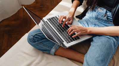person typing on their laptop