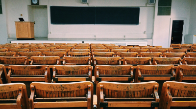 A college classroom with seats and a podium at the front