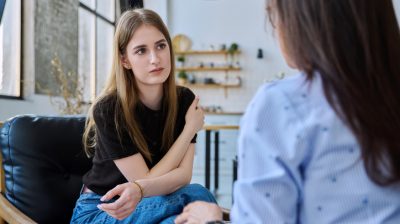 Illustrative image of two seated people conversing in an office.