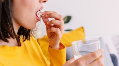 Illustrative image of a person taking a pill.