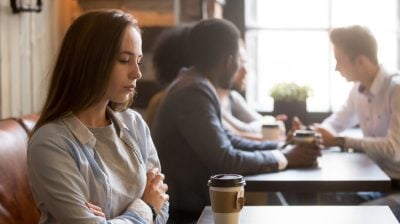 Upset person sitting alone at a coffeeshop.