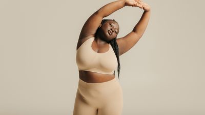 Illustrative image of a serene person stretching their hands above their head with eyes closed.