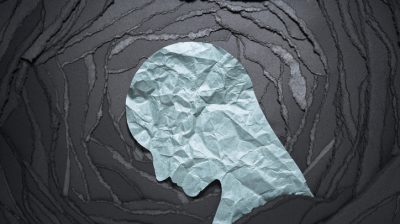 Silhouette of a person's sad head against a black background.