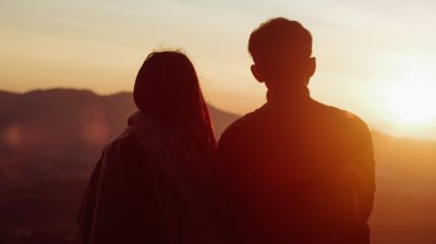The silouette of two people looking at the sunset