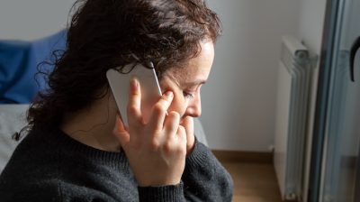 Illustrative image of an upset person talking on their mobile phone.