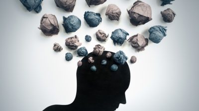 Illustration of a silhouette with lots of abstract shapes representing thoughts in a cloud above the head.