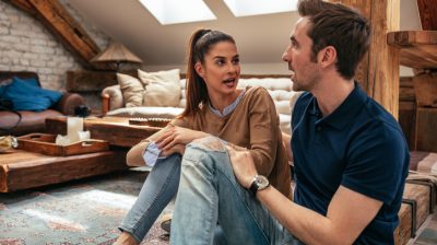 Illustrative image of two people conversing in a cosy room.