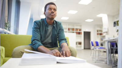 blind man reads braille book in a school
