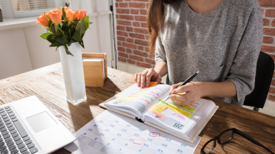 A person filling out a planner