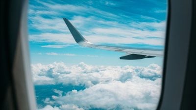 View from an aeroplane window with blue sky and clouds