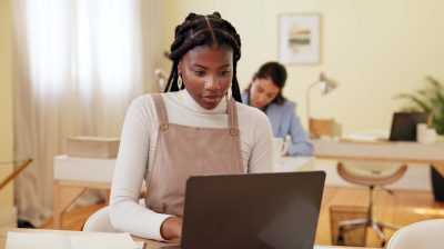 Girl in pinafore dress using internet to fact check information online.