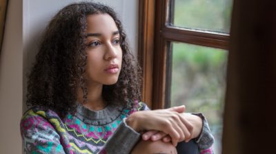 Teenager reflectively looking out the window