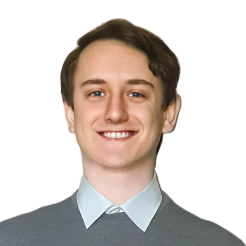 Fintan smiles at the camera in a button down shirt.