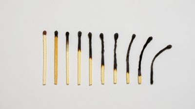 Burned matches in a row on a white background.