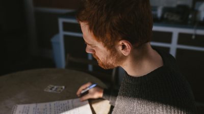 Red haired person writing a letter to a loved one