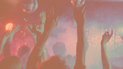 People in a club with their hands raised