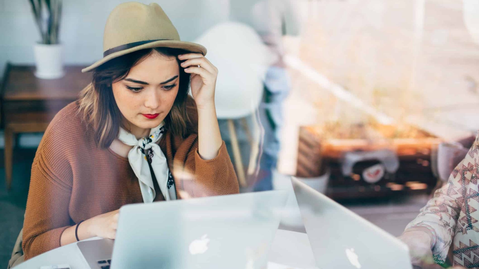 Photo of a student wearing a hat while on a laptop - back to education allowance