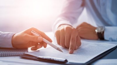 Two people pointing at a document