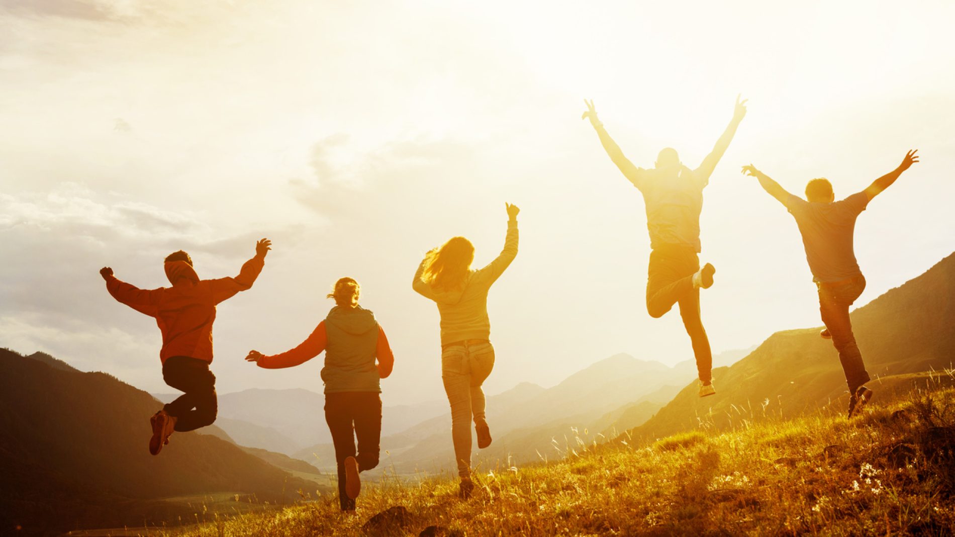 Group of happy friends run and jump