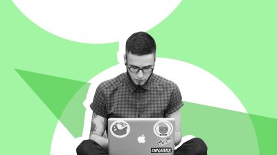 Young man on his laptop in front of a green and white background