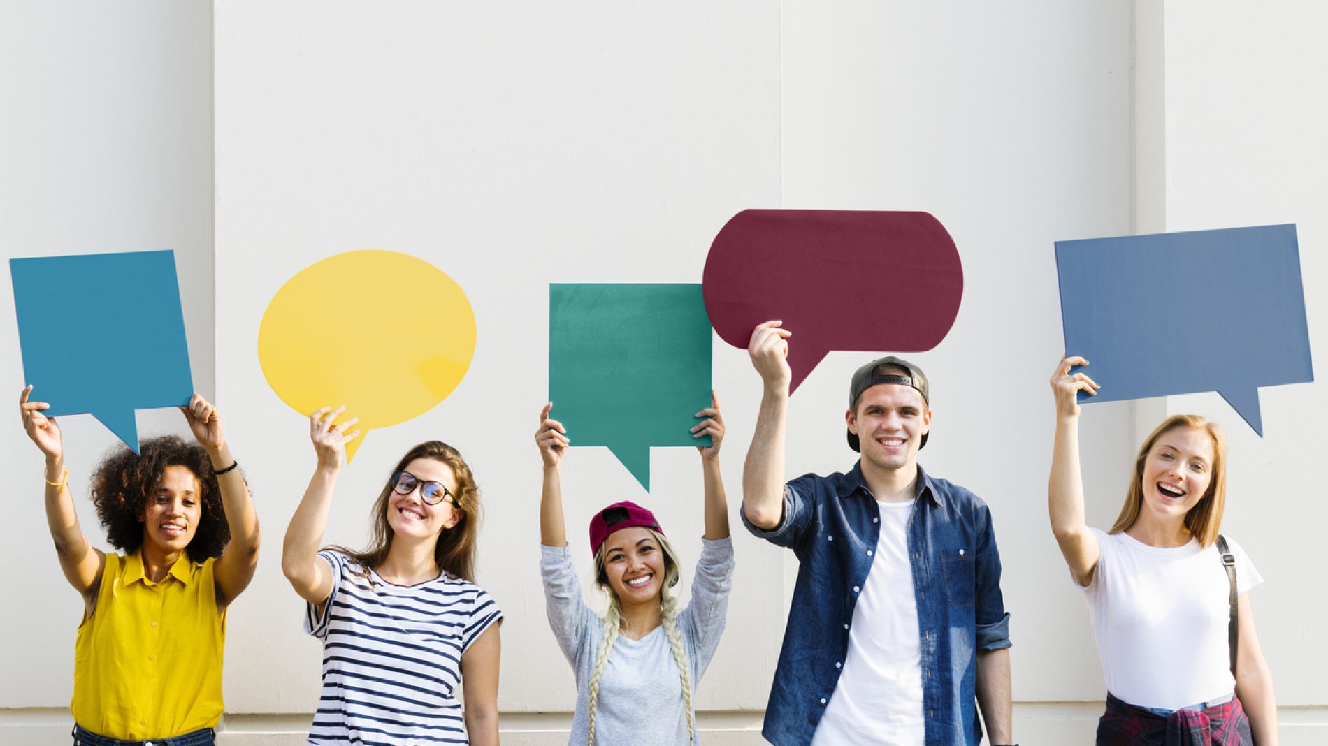 Young adult friends holding up copy space placard thought bubbles