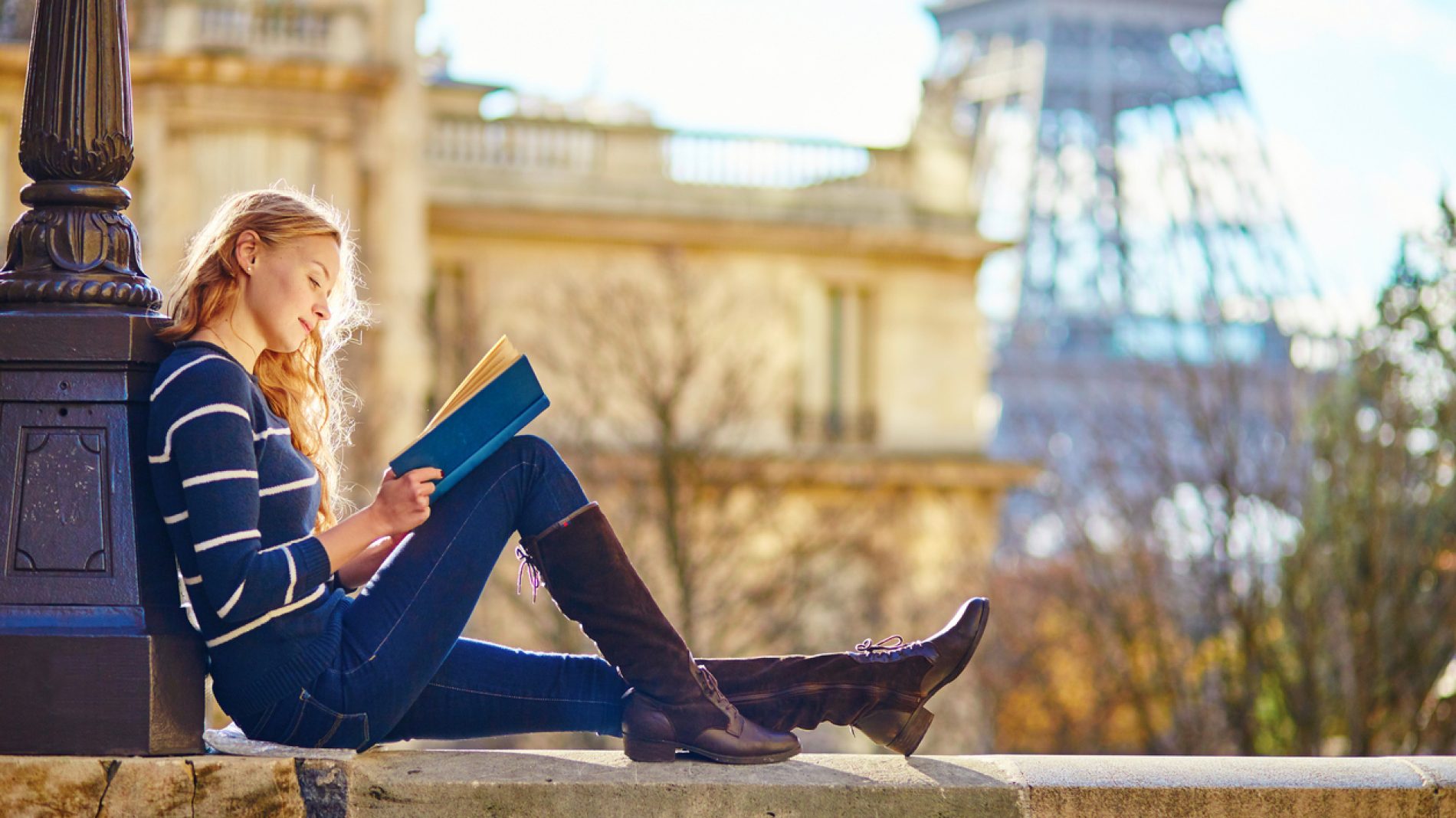 Beautiful woman in Paris, reading a book