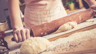 Close up of female baker hands kneading dough.