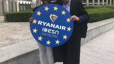 Ryanair worker and Erasmus student holding Ryanair and Erasmus partnership poster