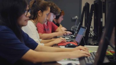 School students studying together in a computer lab