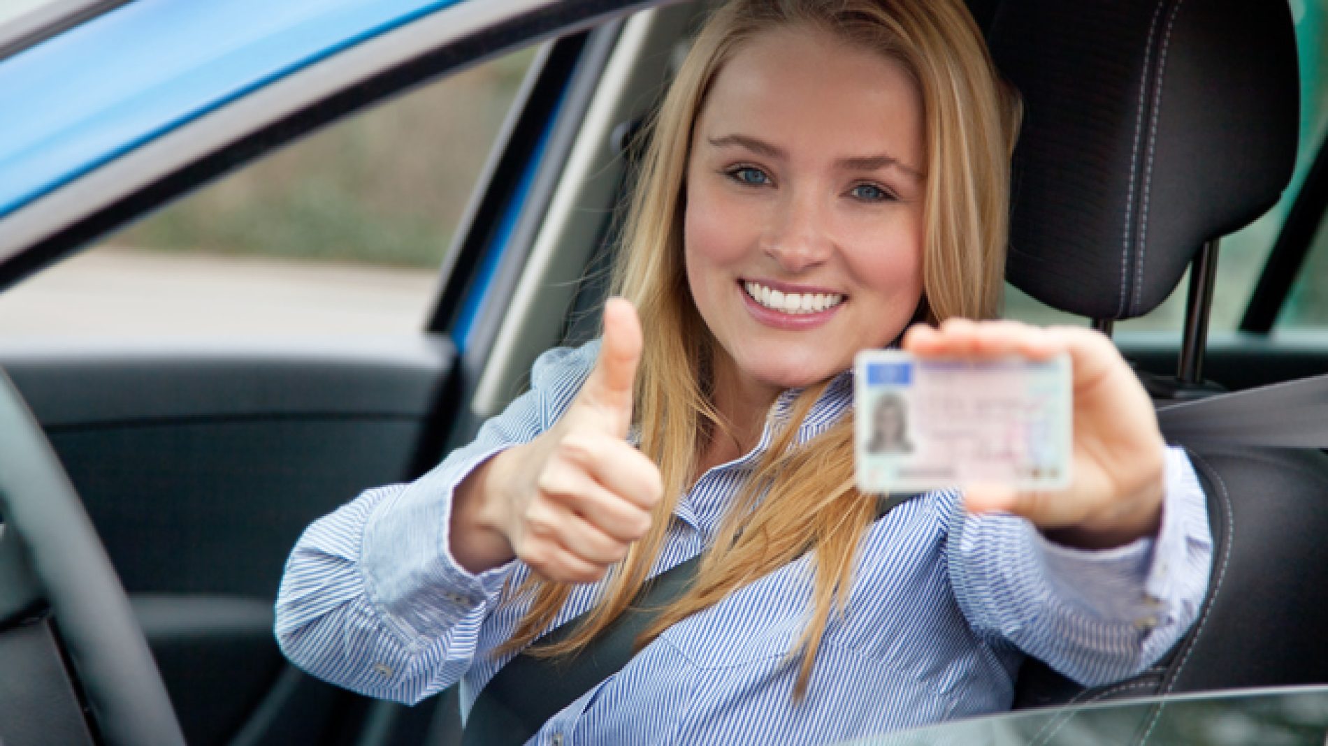 Women holding driving licence in car