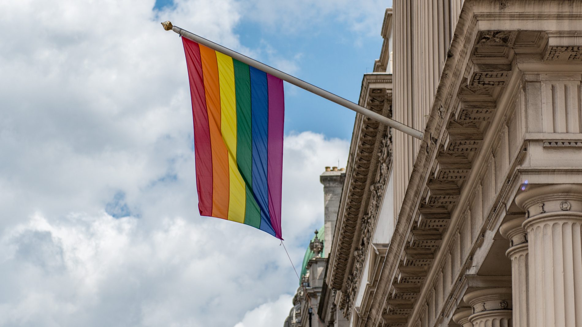 a pride flag hanging from a building