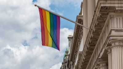 a pride flag hanging from a building